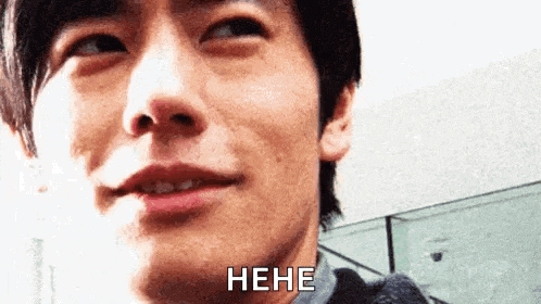 a close up of a man 's face with the words ` ` hee ` ` written on it .