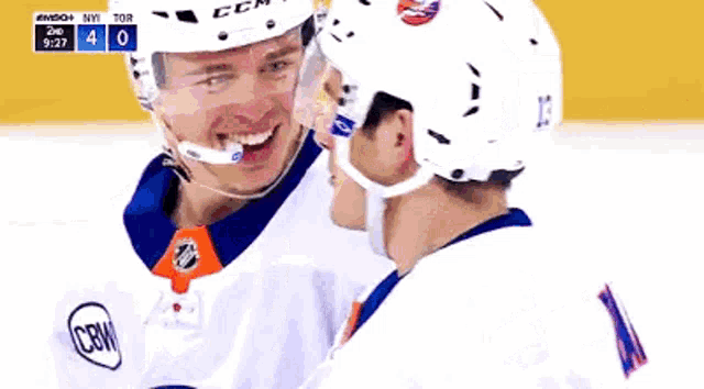 a hockey player with the number 13 on his helmet is hugging another player
