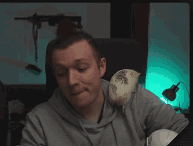 a man with a hedgehog on his shoulder making a funny face