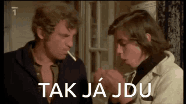 a man smoking a cigarette next to another man with the words tak ja jdu written on the bottom