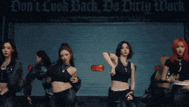 a group of women are dancing in front of a sign that says " do n't look back "
