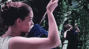 a woman is holding a knife in her hand while standing next to a man .