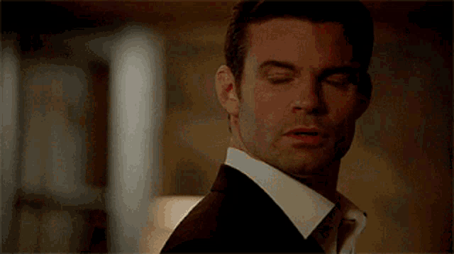 a close up of a man in a suit and tie