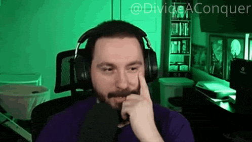 a man with a beard wearing headphones and a purple shirt