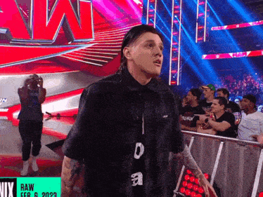 a man stands in front of a sign that says raw feb 6 2022