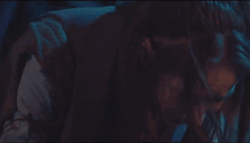 a woman with blood on her face is crying in a dark room in a movie .