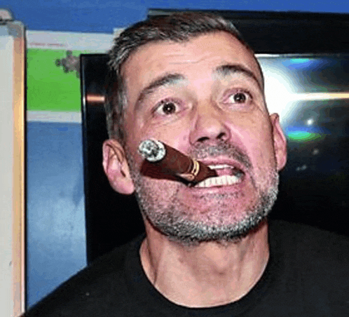 a man with a beard is smoking a cigar .