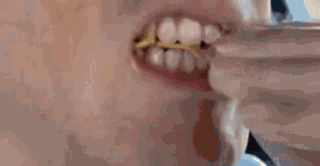 a close up of a person 's mouth with a yellow substance coming out of it .