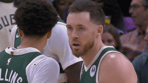 a basketball player with the name allins on his back talks to another player