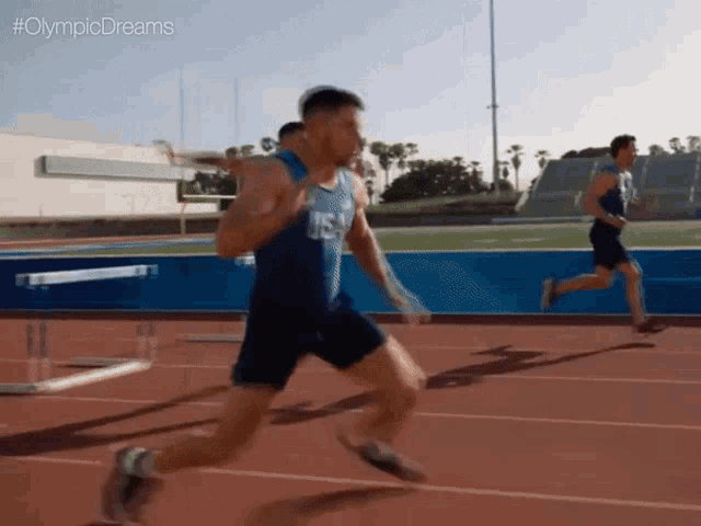 a man running on a track with #olympicdreams written above him