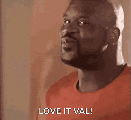 a man with a beard is wearing a red shirt and says `` love it val '' .
