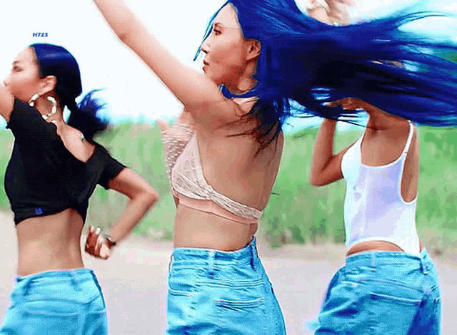 a woman with blue hair is dancing with another woman