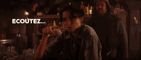 a man and a woman are sitting at a bar with the words herr machin behind them