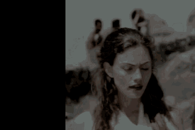 a blurry picture of a woman 's face with a person in the background