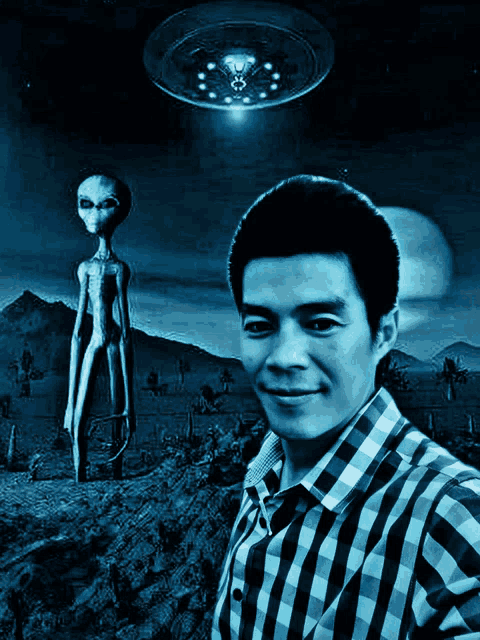 a man in a plaid shirt stands in front of a painting of an alien