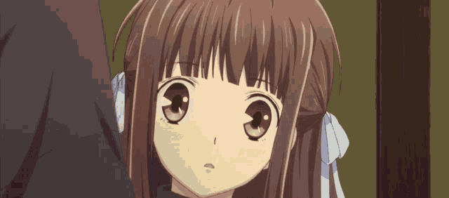 a close up of a girl with brown hair and a white bow in her hair