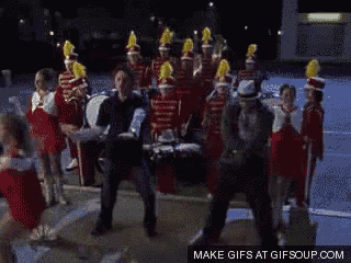a group of people are dancing in front of a marching band and the words make gifs at gifsoup.com
