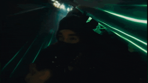 a man wearing a mask is walking down a street at night