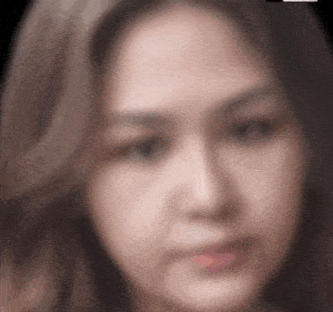 a blurry picture of a woman 's face with a black background .