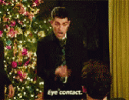 a man standing in front of a christmas tree says eye contact