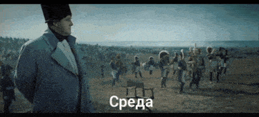 a man in a trench coat stands in front of a field of soldiers with the word среда written on the bottom right