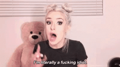 a woman is standing in front of a teddy bear and saying `` i 'm literally a fucking idiot . ''