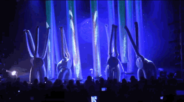a group of elephants are dancing in front of a blue background