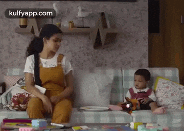 a woman is sitting on a couch with a baby on her lap .
