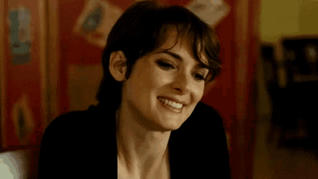 a close up of a woman 's face smiling in a room .