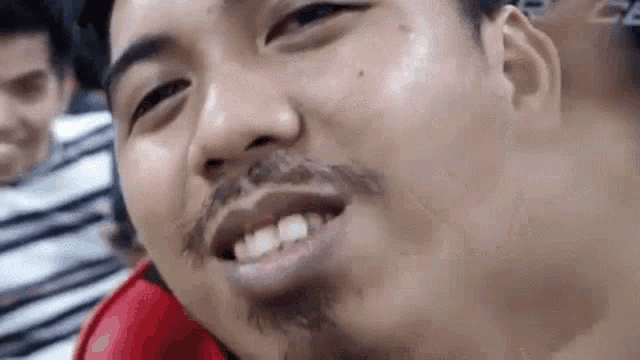 a close up of a man 's face with a beard and a missing tooth .