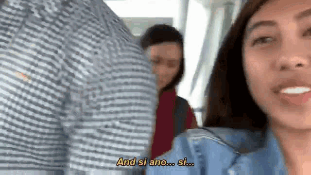 a woman is talking to a man in a striped shirt on a train .