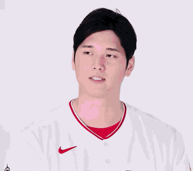 a man wearing a white angels jersey with red lettering