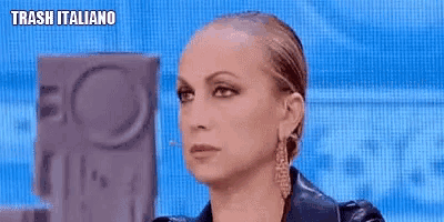 a woman wearing a leather jacket and earrings is looking at the camera .