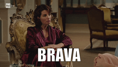 a woman sits in a chair with the word brava written in white