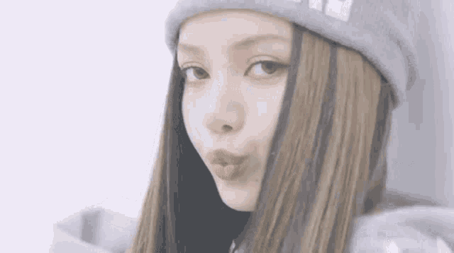 a close up of a woman wearing a hat and a hoodie .