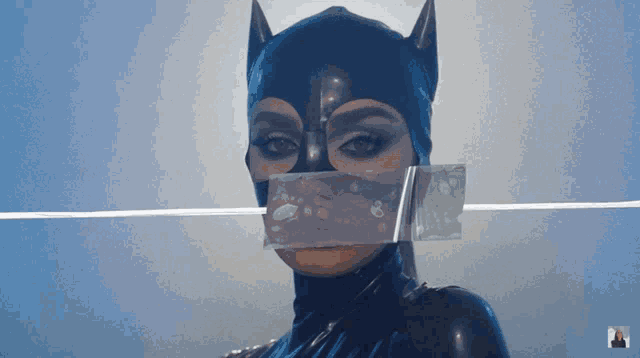 a woman in a catwoman costume has a piece of tape taped to her mouth
