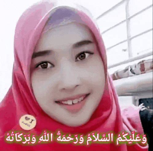 a woman wearing a pink hijab is smiling and has a sticker that says i love you