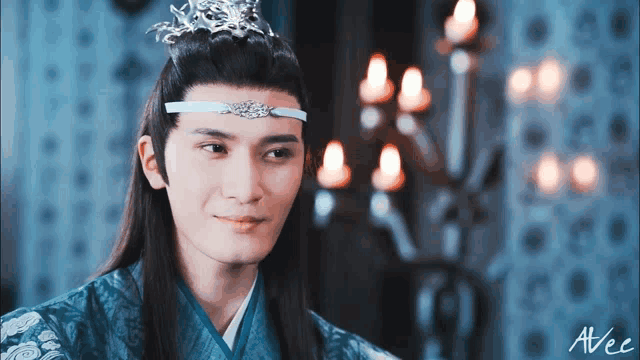 a man wearing a blue kimono and a headband with a crown on his head