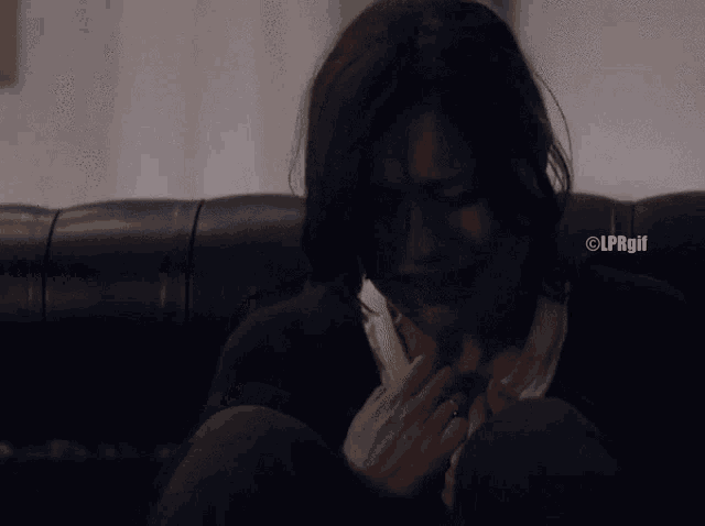 a woman is sitting on a couch with her eyes closed and the watermark clprgif