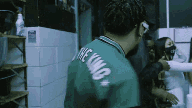 a man in a green shirt that says the king