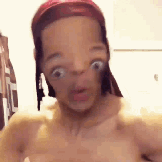 a man without a shirt is wearing a red headband and making a funny face