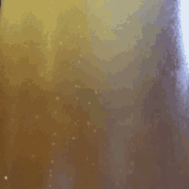 a close up of a glass of liquid with bubbles coming out of it