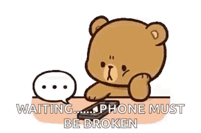 a teddy bear is sitting at a table holding a cell phone and waiting for it to be broken .