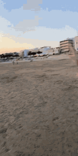 a blurry picture of a beach with buildings in the distance