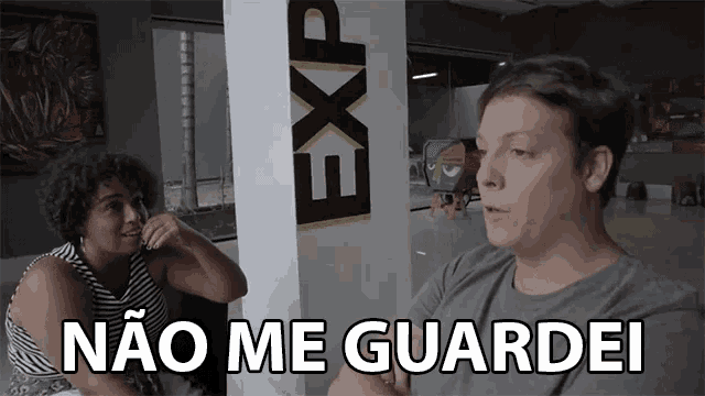 a man and a woman are sitting in front of a wall that says exp