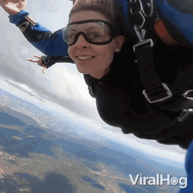 a woman wearing goggles is flying through the air with the words viralhog written below her