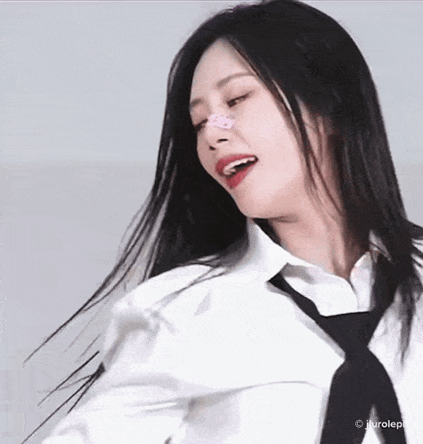a close up of a woman wearing a white shirt and a black tie
