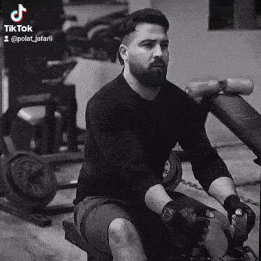 a black and white photo of a man sitting on a machine with tiktok written on the bottom right