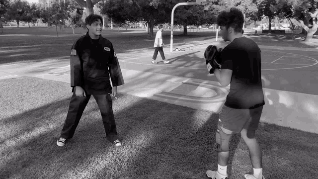 a black and white photo of a man wearing a black shirt that says karate on it