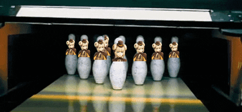 a bowling alley with a row of bowling pins with teddy bears in them